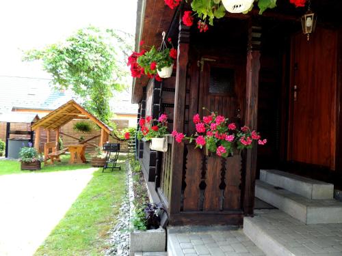 a door with flowers on the side of a house at Bieszczadzkie Wyra in Ustrzyki Dolne