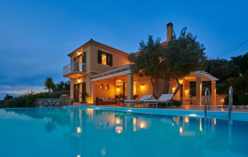 a large swimming pool in front of a house at Artblue Villas in Tsoukaladhes