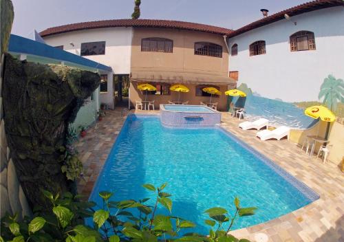 ein großer Pool vor einem Haus in der Unterkunft Hotel Pousada Portal da Palmeira in Ubatuba