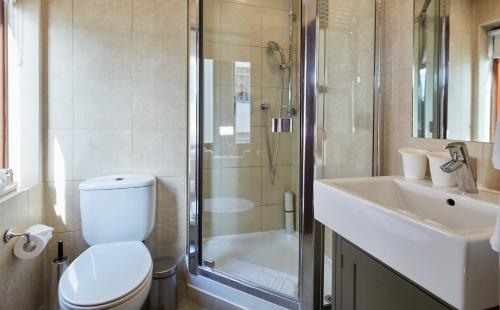 a bathroom with a toilet and a shower and a sink at Cheval Knightsbridge in London