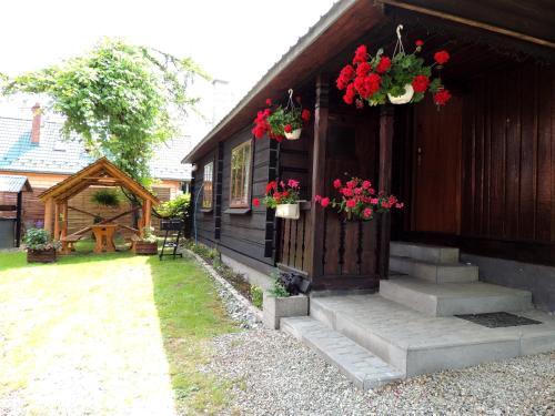 a house with flowers on the front of it at Bieszczadzkie Wyra in Ustrzyki Dolne
