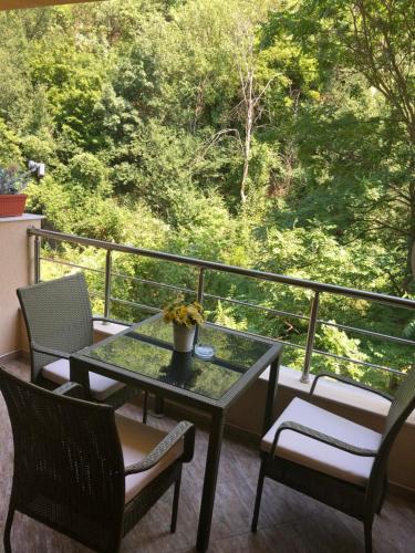 a table and chairs on a balcony with a view at Апартамент Мегилукс in Blagoevgrad