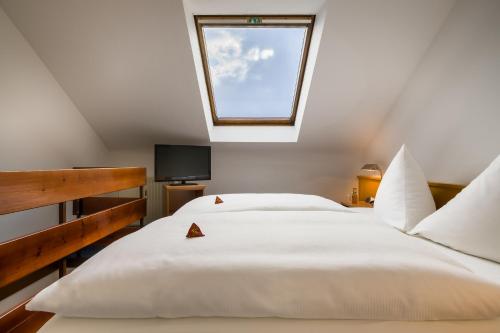 a bedroom with a large white bed with a skylight at acora Karlsruhe Zentrum Living the City in Karlsruhe