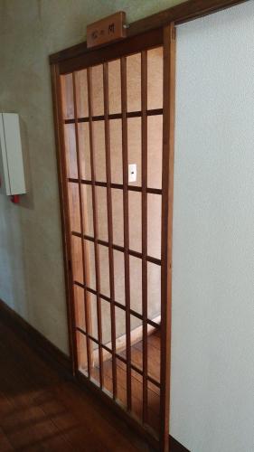 ajar door of a room with a wooden at Walking Pilgrimage Hotel Tokiwa Ryokan in Ōzu