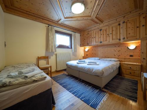 a bedroom with two beds and a wooden ceiling at Residence Livigno MyHolidayLivigno in Livigno