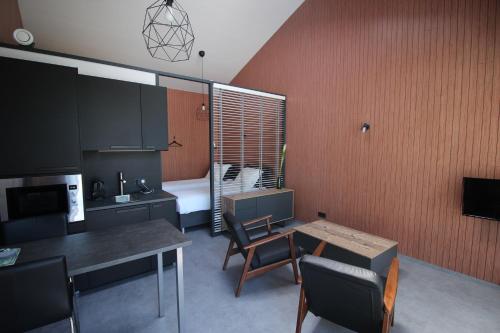 a kitchen with a table and a room with a bed at Bij ons 'Niek in Den Dungen