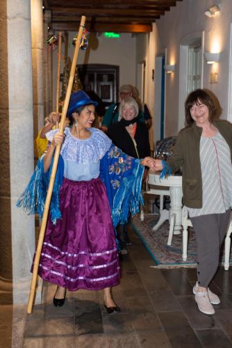 a woman in a dress holding a large stick at Illa Experience Hotel in Quito