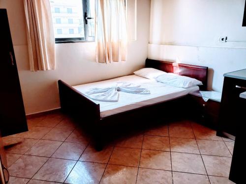 a small bed in a room with a window at The First Hotel Saranda in Sarandë