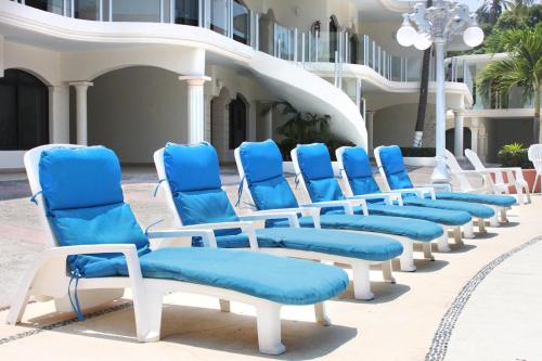 a row of blue and white chairs on a patio at Hotel Costa Azul in Acapulco