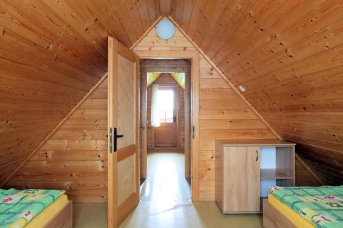 pokój z 2 łóżkami w drewnianym domu w obiekcie Trzy Czajki Domki letniskowe w Wiciu