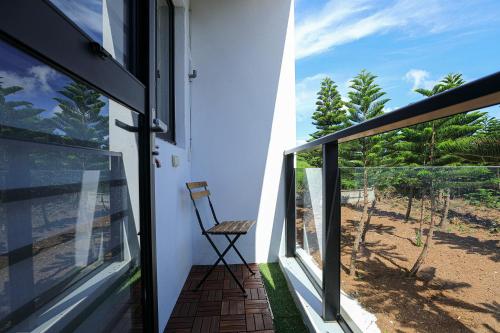 a room with a chair on a balcony with a window at Cheese Cookie Homestay in Magong