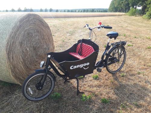 una bicicleta estacionada junto a un fardo de heno grande en Pension Marina, en Lauta Dorf