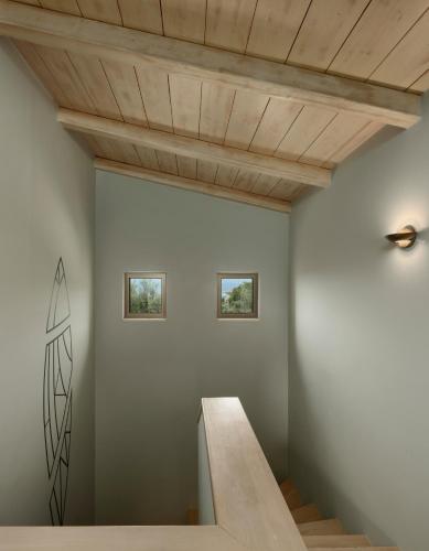 a staircase in a room with a wooden ceiling at Artblue Villas in Tsoukaladhes