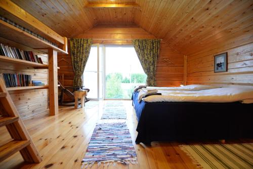 a bedroom with two beds and a large window at Kliukai in Dubingiai