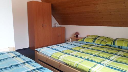 a bedroom with two beds and a wooden ceiling at Happy Chalet in Černý Dŭl