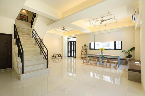 a living room with a staircase and a dining room at Cheese Cookie Homestay in Magong
