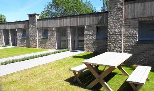 a picnic table and bench in front of a brick building at Terrasses de Malmedy F&L triplex 214 et studio 320 et 317 et Studio supérieur 340 in Malmedy