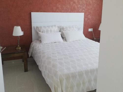 Cama blanca con 2 almohadas y mesa con lámpara en AMAY 880 Nr 38 en Torrevieja
