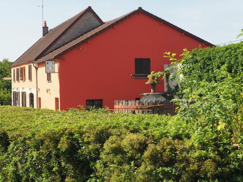 a red and white house behind a hedge at Hôtel Restaurant La Manse in Dornecy