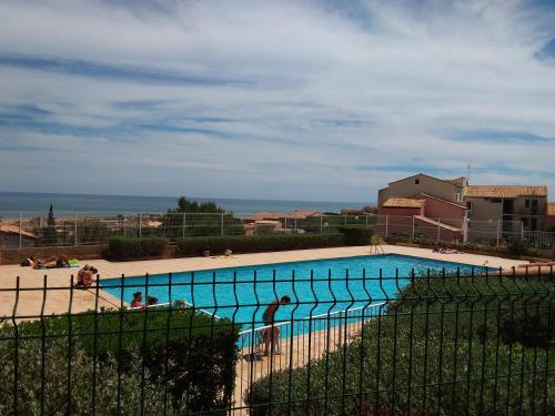 una grande piscina con l'oceano sullo sfondo di terrasses de la méditerranée a Fleury