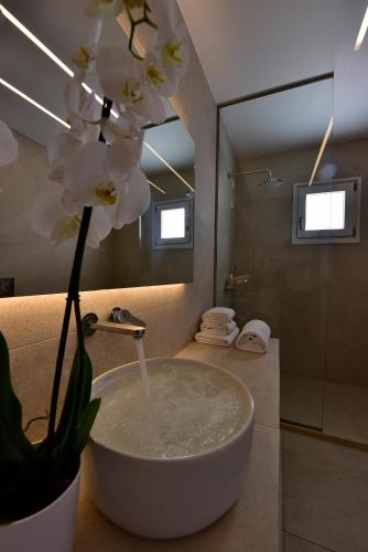 a bathroom with a bowl sink and a mirror at Margie Mykonos Hotel in Mikonos