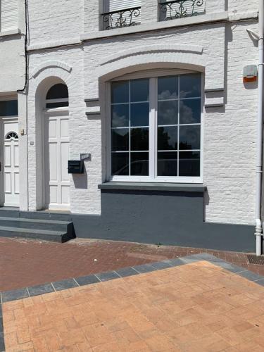 un bâtiment blanc avec une fenêtre sur le côté dans l'établissement Musica, à Bray-Dunes