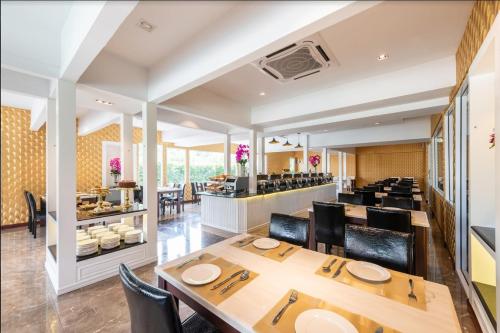 a dining room with tables and chairs and a restaurant at Napheera Royal Tel in Ban Khlong Bang Krathiam