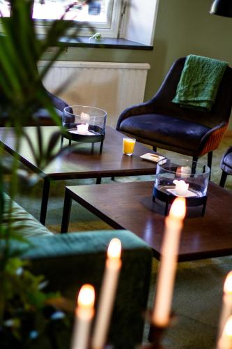 a living room with tables with candles and a chair at Hotel Hehrne Kök & Konferens in Vänersborg
