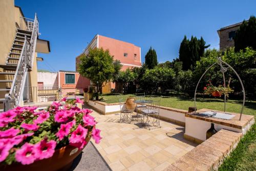 a patio with a table and chairs and pink flowers at B&B PROCHYTEA in Procida