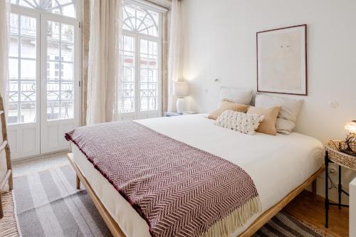 um quarto com uma cama grande e uma janela grande em BOUTIQUE Rentals-Flores Plaza in city historical center no Porto