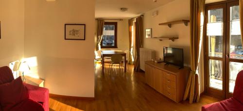 a living room with a television on a dresser and a table at R.T.A. Hotel Monte Rosa in Champoluc