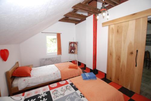 une chambre avec deux lits et une armoire en bois dans l'établissement Apartment Cats, à Donji Milanovac