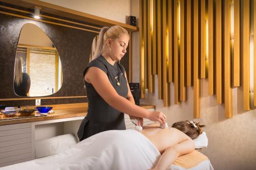 a woman giving a client a massage at Hotel Sevtopolis Medical & SPA in Pavel Banya