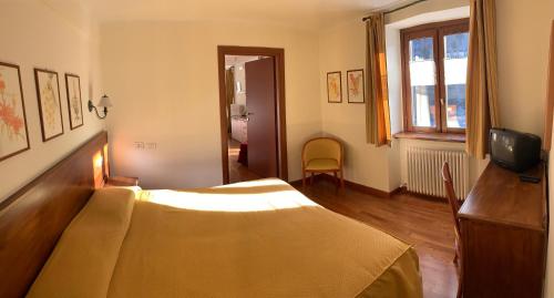 a hotel room with a bed and a window at R.T.A. Hotel Monte Rosa in Champoluc