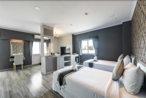 a bedroom with a large bed and a television at Napheera Royal Tel in Ban Khlong Bang Krathiam