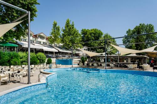 a large swimming pool with tables and chairs at Romantique Veles Hotel in Veles