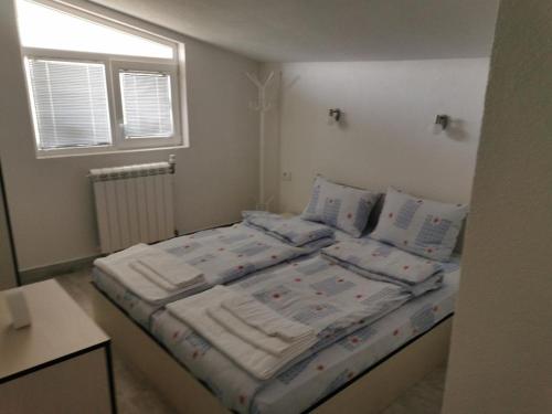 貝羅沃的住宿－Diva Kompani Rooms，一间卧室配有带3个枕头的床和窗户。