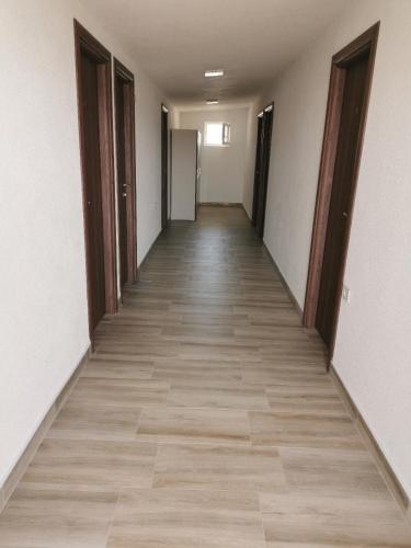 an empty hallway with wooden floors and doors at Diva Kompani Rooms in Berovo