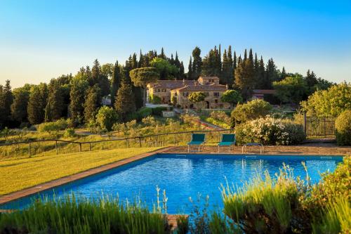 a pool in a yard with a house in the background at Le Filigare Winery & Accomodation in Chianti in San Donato in Poggio