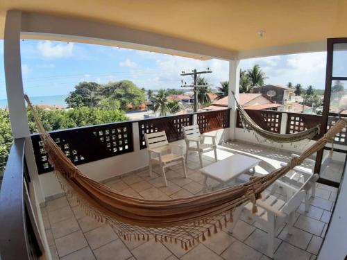 a hammock on the balcony of a house at Pousada Mirante do Pontal in Coruripe