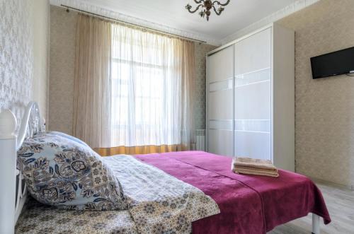 een slaapkamer met een bed met een paarse deken bij Rest Home in Sumy