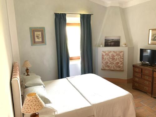 ein Schlafzimmer mit einem Bett und einem Fenster in der Unterkunft Magnolia House in Cetona