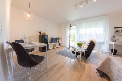 a living room with a desk and chairs and a table at Holiday Appartement »Achalm« mit Sonnenterrasse in Reutlingen