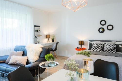 a living room with a blue couch and a table at Holiday Appartement »Achalm« mit Sonnenterrasse in Reutlingen