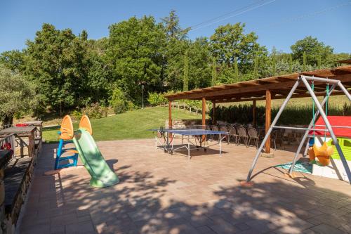 a patio with a table and chairs and a playground at Podere Cerretino in Poppi