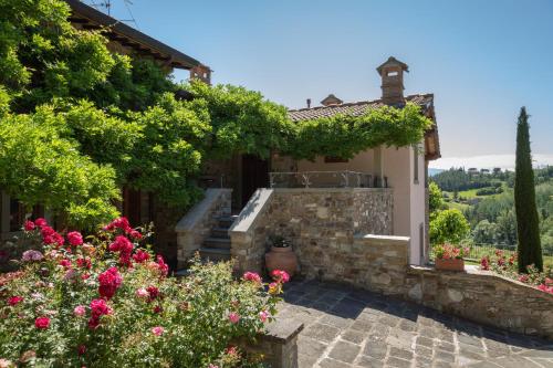 a stone house with flowers in the yard at Podere Cerretino in Poppi