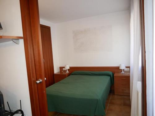 a small bedroom with a green bed in a room at Cabirol-Vacances Pirinenca in Incles