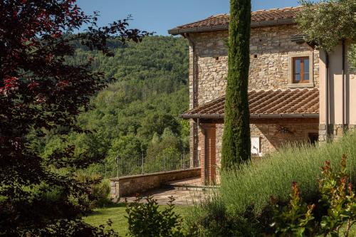 a stone house with a view of a forest at Podere Cerretino in Poppi