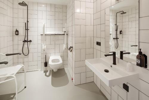 a bathroom with a toilet, sink, and bathtub at Hotel the Match in Eindhoven