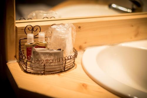 a bathroom sink with a basket next to a sink at Montana Chalet Hôtel & Spa in Le Sauze